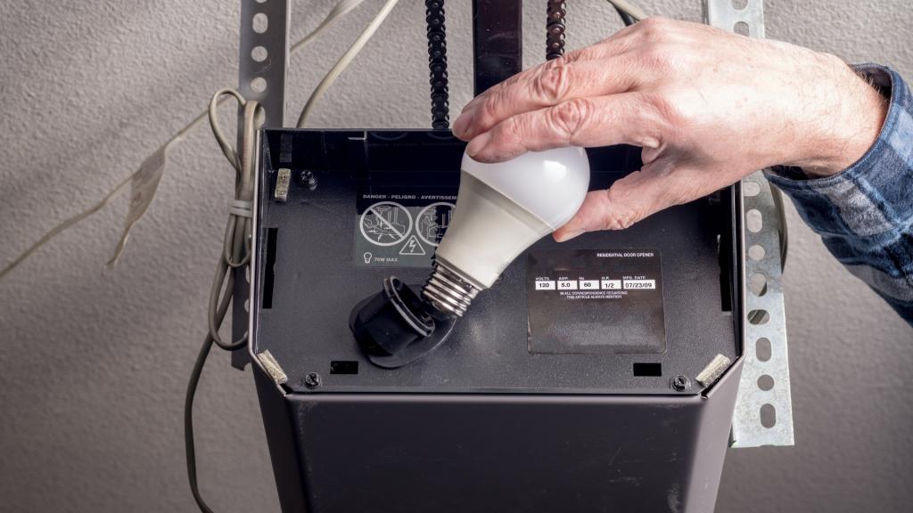 Replacing the opener's light bulb during winter garage door maintenance