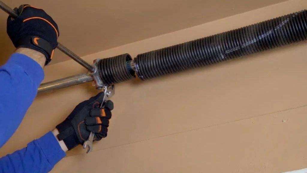 Professional working on garage door with a broken spring
