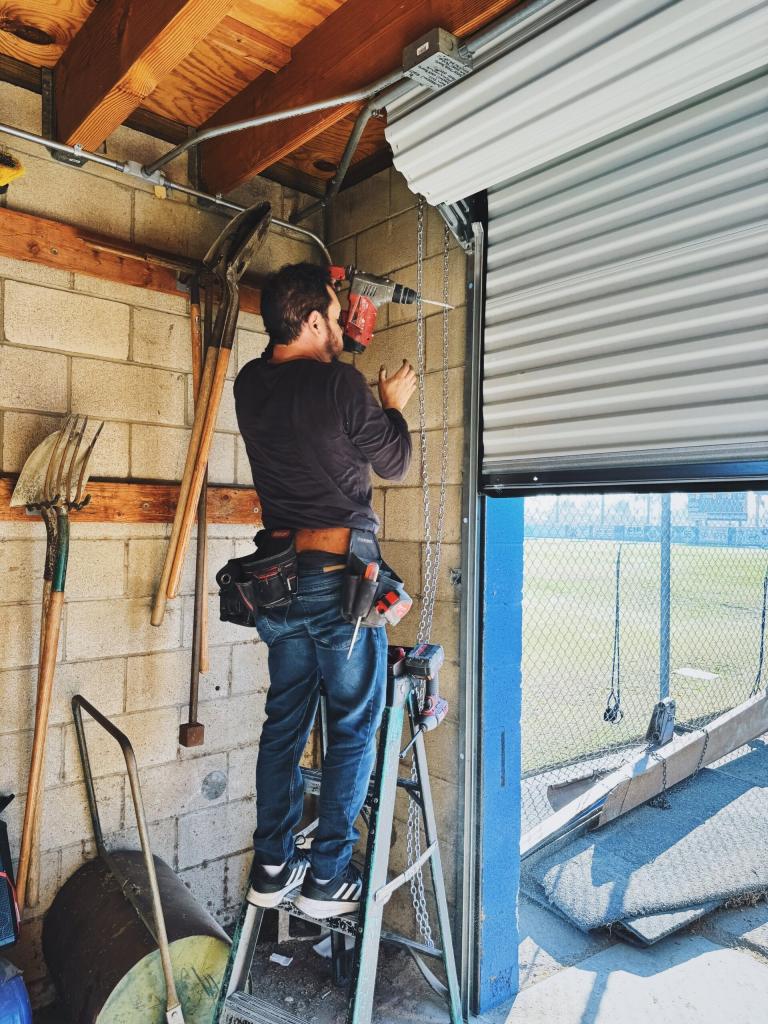 A licensed expert performing a garage door installation in Santa Ana